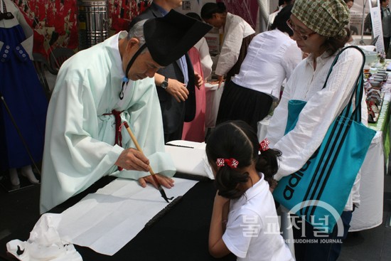 유교 체험관에서는 ‘가훈 써주기’를 진행했다. 한 아이와 엄마가 어떤 가훈이 써질지 유심히 바라보고 있다.