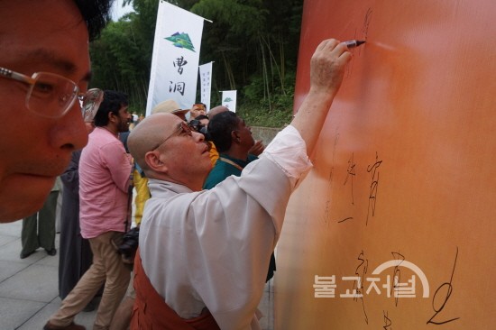 보적사 경내에 마련된 대형 현수막 방함록에 서명을 하고 있는 영담 스님.