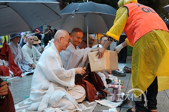 촛불법회 경비 모금에 동참하고 있는 명진 스님과 전국선원수좌회 의장 월암 스님.