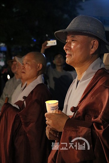 전국선원수좌회 의장 월암 스님이 촛불을 들고 있다.
