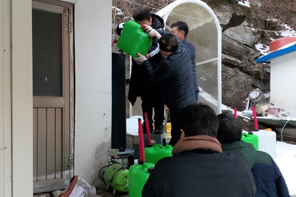 홍천 수타사신도회 회원들이 말통에 담아 직접 옮긴 난방유를 지원하고 있다. 사진 제공 홍천 수타사신도회.